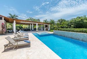 a swimming pool with lounge chairs and a house at LAS CANAS 20 POOL JACUZZI GAMES HIBACHi STAFF in La Romana