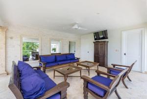 a large living room with blue couches and tables at VILLA BLANCA CHEF BUTLER MAiD POOL JACUZZI NEAR THE BEACH in Punta Cana