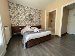 una camera d'albergo con letto e parete di Le Relais De La Place a Le Faou
