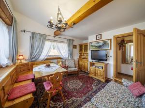 sala de estar con mesa y TV en Villa Casanova - Stayincortina, en Cortina dʼAmpezzo