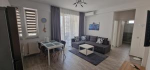 a living room with a couch and a table at Sea Sound Apartment Mamaia Nord in Mamaia Sat/Năvodari