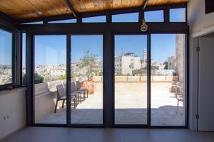 eine offene Glastür mit Blick auf eine Terrasse in der Unterkunft Dar As-Sideh pilgrim house in Bethlehem