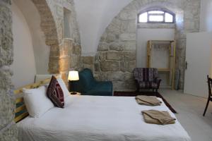 ein Schlafzimmer mit einem großen Bett in einer Steinmauer in der Unterkunft Dar As-Sideh pilgrim house in Bethlehem