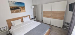 a bedroom with a white bed and a tv at Sea Sound Apartment Mamaia Nord in Mamaia Sat/Năvodari