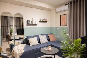 - un salon avec un canapé bleu et une table dans l'établissement Three doors apartments, Strawberry Studio, à Tirana