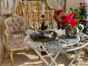 una mesa con un jarrón de flores y una vela en Thracian Cliffs Private Apartment, en Kavarna