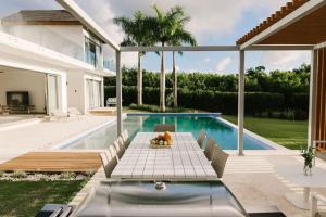 een huis met een zwembad en een patio bij VILLA BELLA LUNA WITH CHEF MAiD GOLF CART AND POOL in Punta Cana
