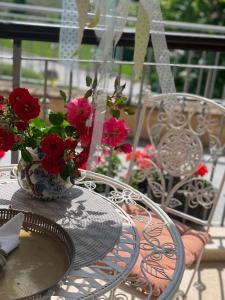 una mesa con un jarrón de flores rojas. en Thracian Cliffs Private Apartment, en Kavarna