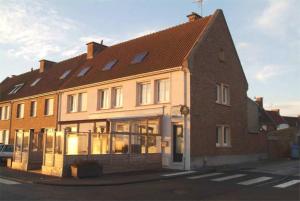 a large brick building with windows on a street at L'univers in Grand-Fort-Philippe