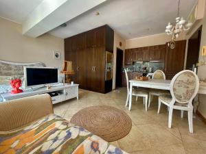 a living room with a television and a table with chairs at Thracian Cliffs Private Apartment in Kavarna