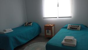una habitación con 2 camas y una mesa con toallas en Casa en el mar en Puerto Pirámides
