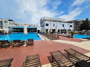 a swimming pool with chairs and umbrellas next to a building at SunBorn Hotel in Golem