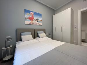 a bedroom with a large bed and a painting on the wall at Adelasia al Corso in Alassio +33 photos