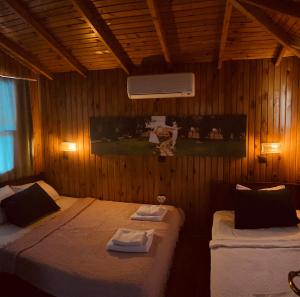 a bedroom with two beds in a wooden wall at Olympos Çınar Hotel in Olympos