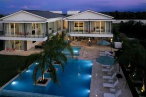 - une vue aérienne sur une maison avec une piscine la nuit dans l'établissement LAS PALMAS 77 Access to Eden Roc Beach Club Chef Butler and maid, à Punta Cana