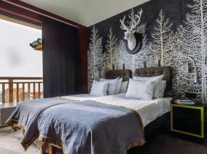 a bedroom with a bed with a black and white wall at Langley Hôtel Tango in Val Thorens