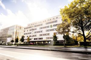 ein großes weißes Gebäude in einer Stadtstraße in der Unterkunft B&B Hotel Wiesbaden in Wiesbaden