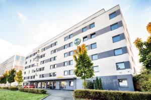 ein weißes Gebäude mit einem Baum davor in der Unterkunft B&B Hotel Wiesbaden in Wiesbaden