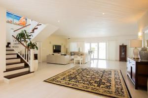 a large living room with a staircase and a rug at TORTUGA B7 GOLF FRONT VILLA WITH POOL CART AND MAiD in Punta Cana