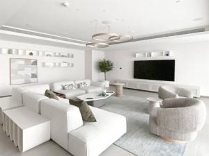 Il comprend un salon doté d'un mobilier blanc et d'une télévision à écran plat. dans l'établissement Trophy - Island Escape Seaview Suite, à Dubaï