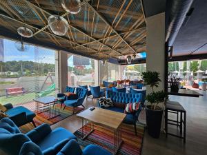 a living room with blue couches and tables and windows at SunBorn Hotel in Golem