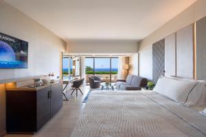 a hotel room with a large bed and a living room at Four Seasons Hotel in Limassol