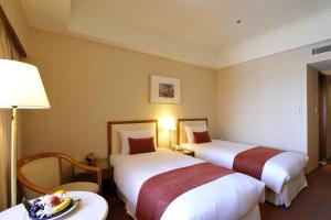 pokój hotelowy z 2 łóżkami i stołem w obiekcie Hotel Riverview Taipei w Tajpej