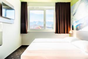 a hotel room with two beds and a window at B&B Hotel Villach in Villach