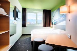 B&B Hotel Villach في فيلاخ: غرفة فندقية بسريرين وطاولة