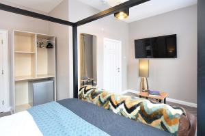 a bedroom with a bed and a flat screen tv at Anam Cara House - Guest Accommodation close to Queen's University in Belfast
