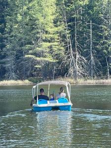 a group of people riding on a boat in the water at Ladd Pond Cabins and Campground, LLC in Colebrook