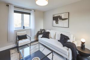 a living room with a couch and a glass table at Vert Vale Apartment in Newcastle upon Tyne