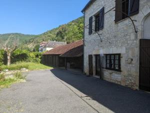 an empty road in front of a stone building at Sweet Home Dordogne between Sarlat-Souillac in Peyrillac-et-Millac