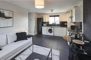 a living room with a couch and a kitchen at Vert Vale Apartment in Newcastle upon Tyne