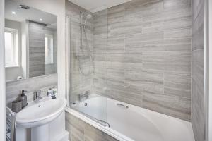 a bathroom with a white tub and a sink at Vert Vale Apartment in Newcastle upon Tyne