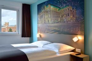 Un dormitorio con una cama con un cuadro en la pared. en B&B Hotel Wien-Hbf, en Viena