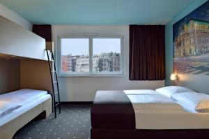 Un dormitorio con dos literas y una ventana. en B&B Hotel Wien-Hbf, en Viena