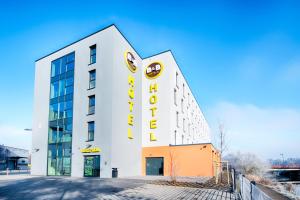 ein weißes Gebäude mit einem gelben Schild darauf in der Unterkunft B&B Hotel Wetzlar in Wetzlar