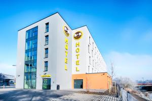 un bâtiment blanc avec un panneau jaune dans l'établissement B&B Hotel Wetzlar, à Wetzlar