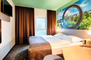 a hotel room with two beds and a mirror at B&B Hotel Wetzlar in Wetzlar