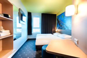 エッテンハイムにあるB&B Hotel Rust-Ettenheimのベッド2台とテーブルが備わるホテルルームです。
