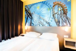 a bedroom with a bed and a poster of a ferris wheel at B&B Hotel Rust-Ettenheim in Ettenheim
