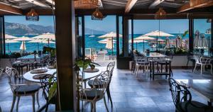 a restaurant with tables and chairs and a view of the ocean at Hotel Turunç-Malmen in Turunç