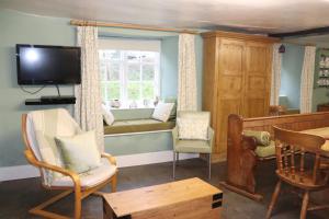 a living room with a couch and a window at Ashclyst Farm Rural Retreat in Exeter