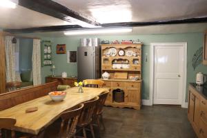 cocina con mesa de madera y nevera en Ashclyst Farm Rural Retreat en Exeter