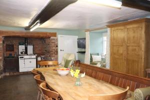 a dining room with a wooden table and chairs at Ashclyst Farm Rural Retreat in Exeter