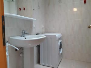a white bathroom with a sink and a toilet at Villa a schiera con uso piscina in Aprilia Marittima