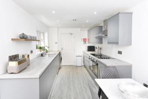 a white kitchen with white counters and appliances at Anam Cara House - Guest Accommodation close to Queen's University in Belfast