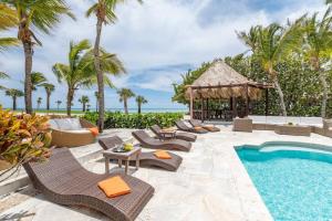 eine Außenterrasse mit einem Pool, Stühlen und einem Pavillon in der Unterkunft CALETON 8 OCEAN VIEW WITH POOL CHEF BUTLER MAiD EDEN ROC BEACH CLUB ACCESS in Punta Cana