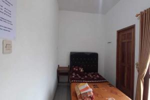 OYO 92628 Raja Alam Homestay في Karanganyar: غرفة نوم صغيرة مع سرير في غرفة